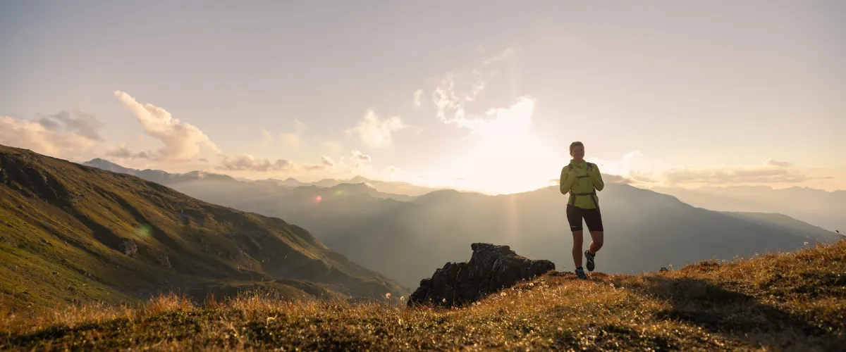 Wanderin im Zillertal auf einem Bergweg mit Panorama über die Alpen